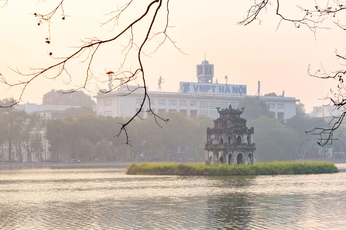 A large building with a blue sign on it sits next to a body of water.