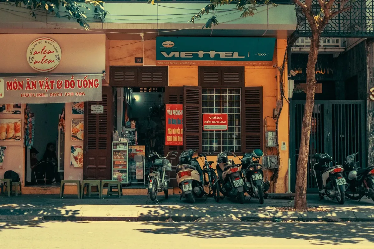 A row of motorcycles parked in front of a yellow building.