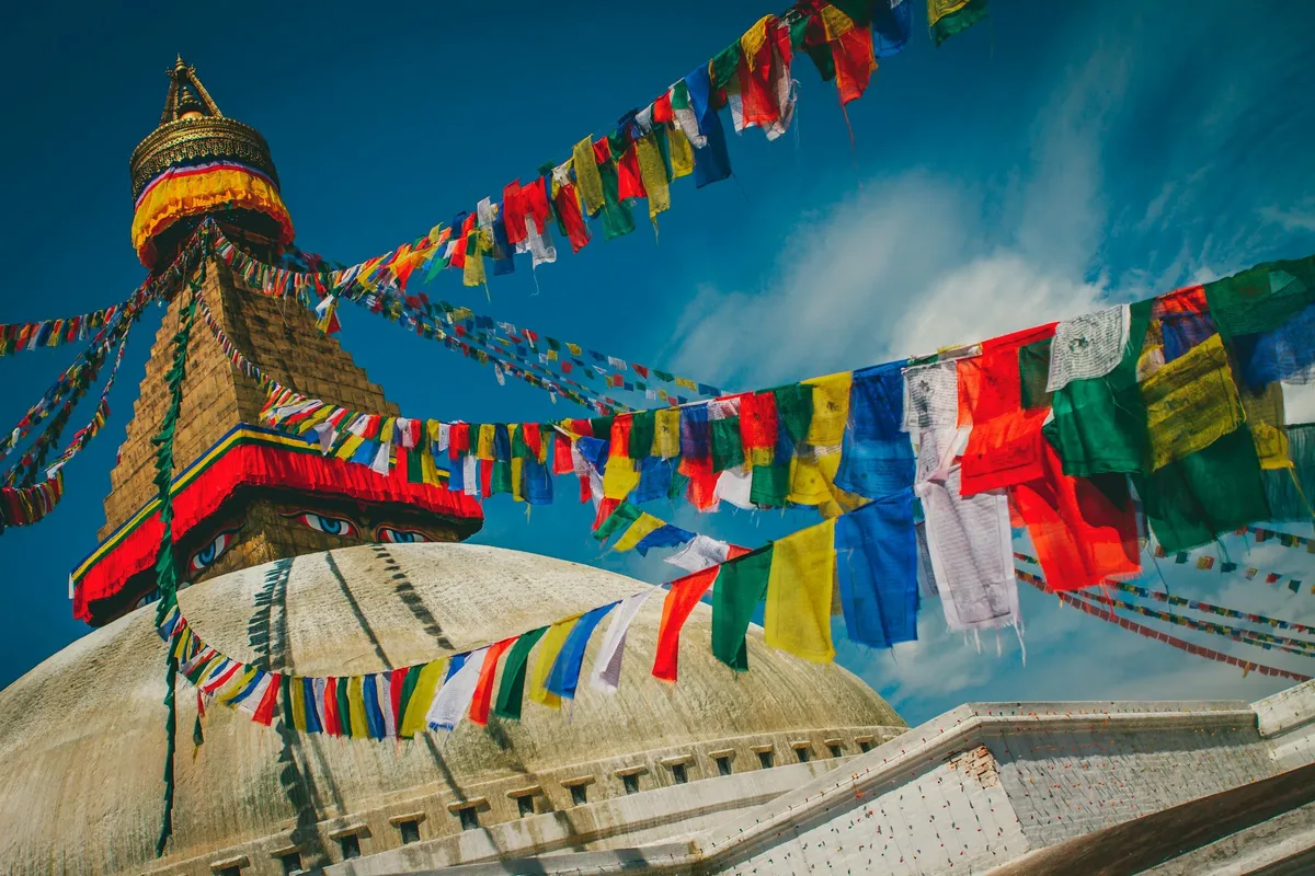 Prayer flags strung from the white dome of Boudhanath Stupa