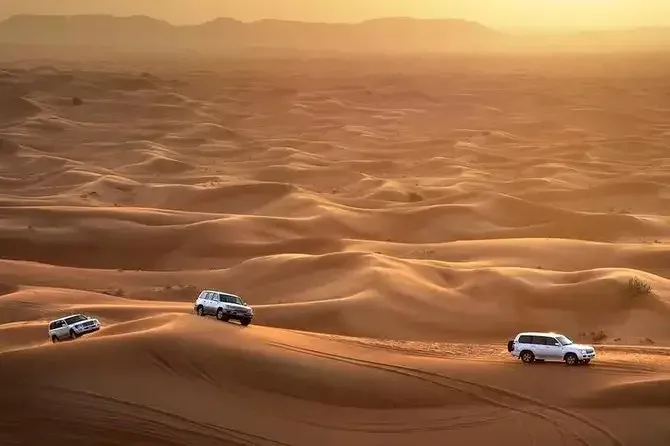 4x4s driving across golden sand dunes