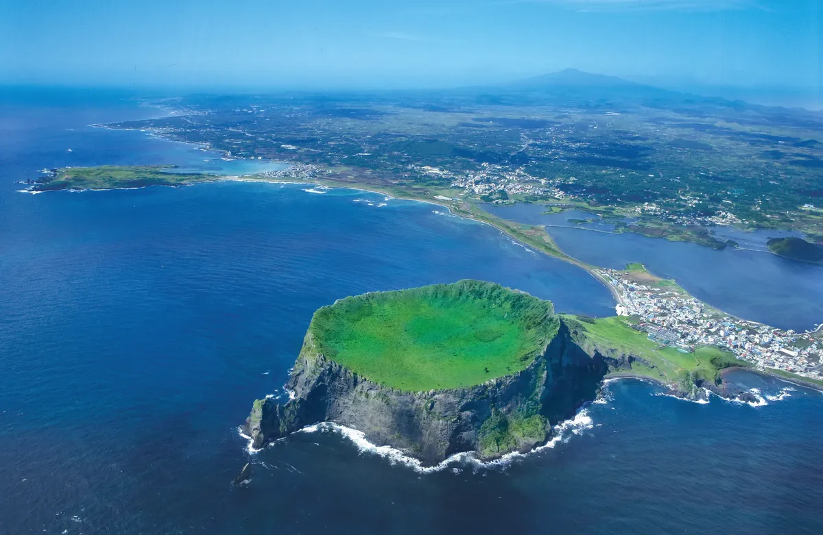 Seongsan Ilchulbong, a green volcanic crater on the coast of Jeju, from the air