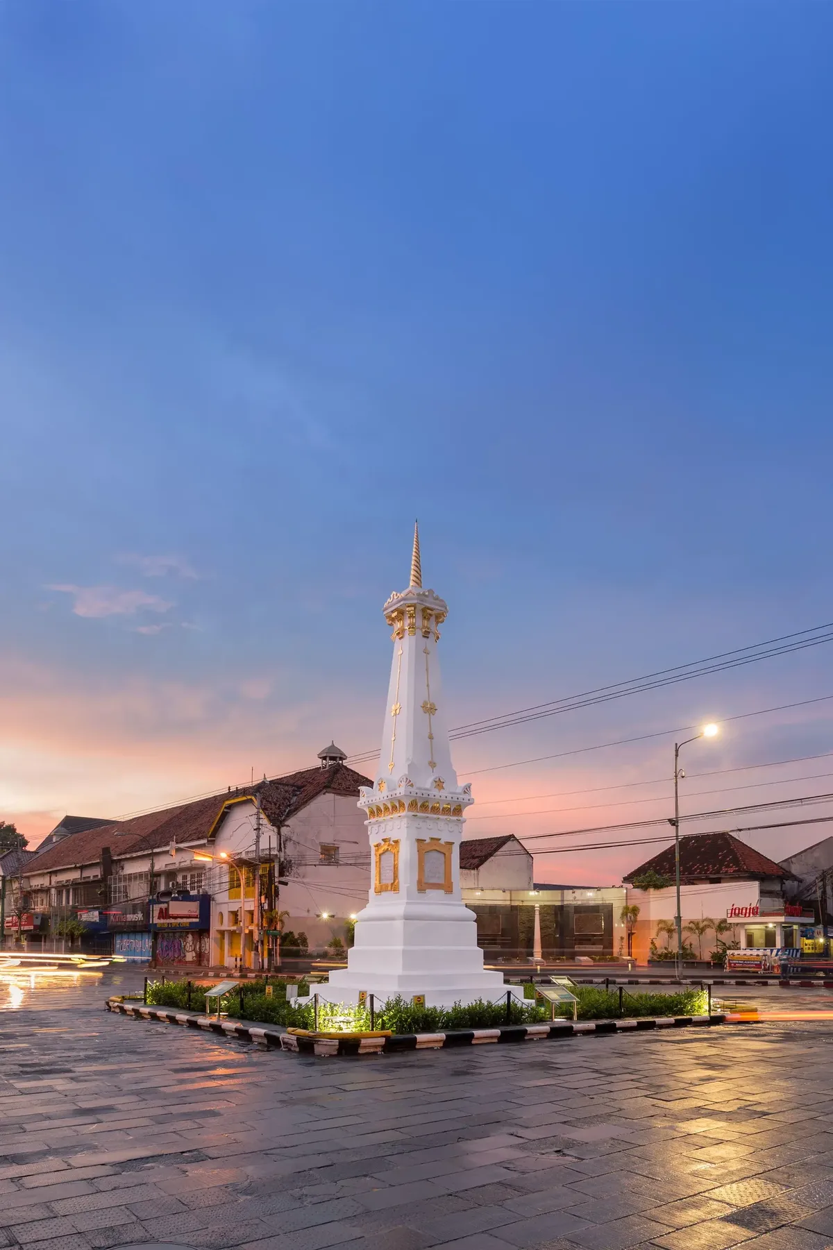 The Tugu monument at a crossroads in Yogyakarta at dusk