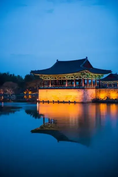 A palace pavilion reflected in Anapji Pond at dusk in Gyeongju