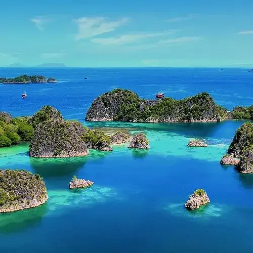 Small limestone islands in clear blue water in Raja Ampat