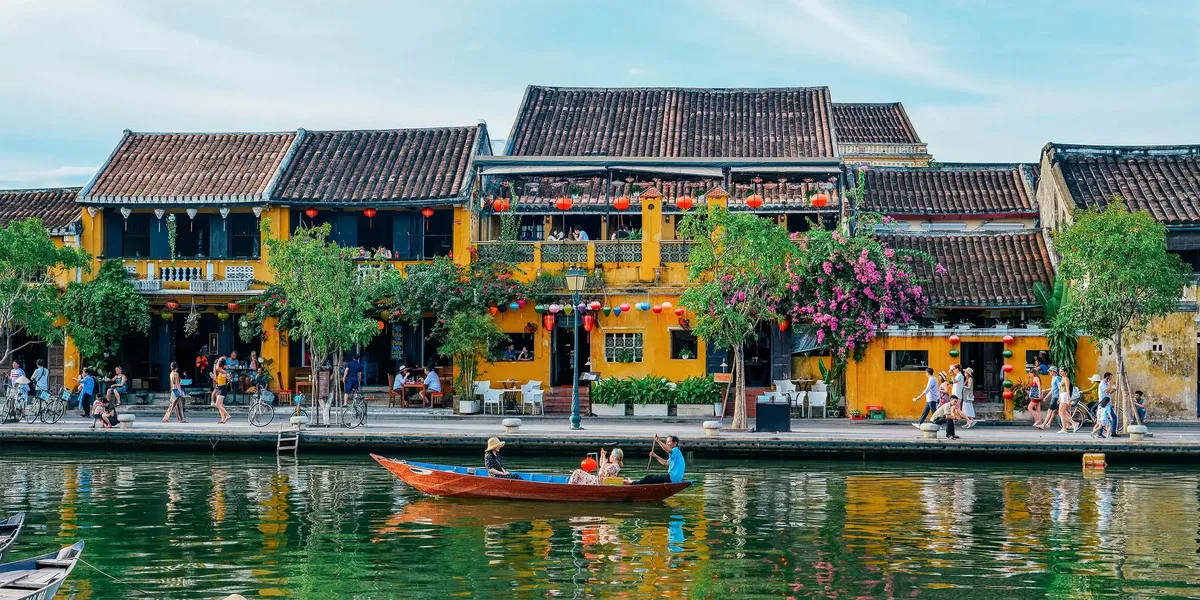 Yellow shophouses and boats along the river in Hoi An old town