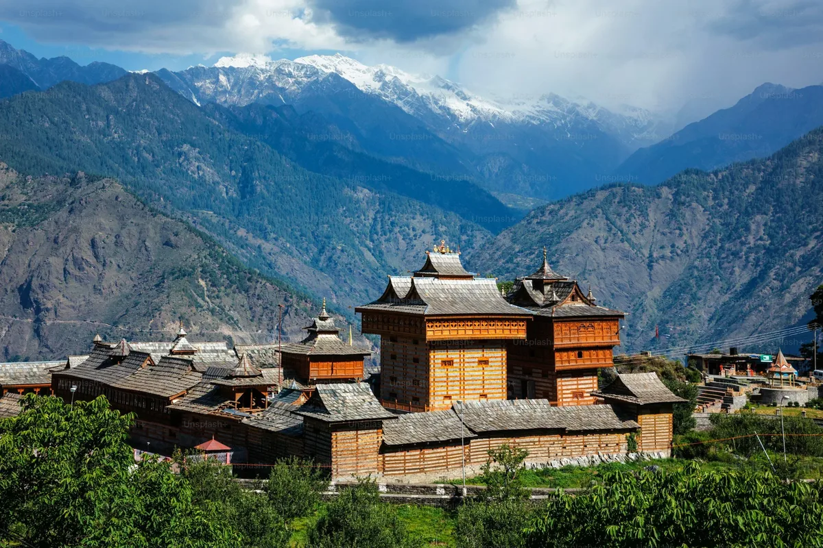 A Bhutanese dzong in a green valley below snowy mountains