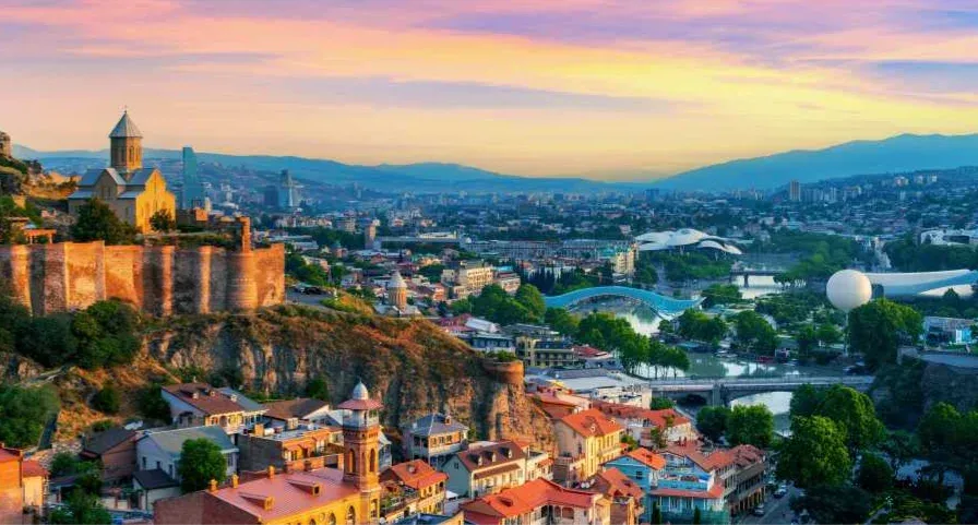 A cityscape with a castle and a bridge over a river.