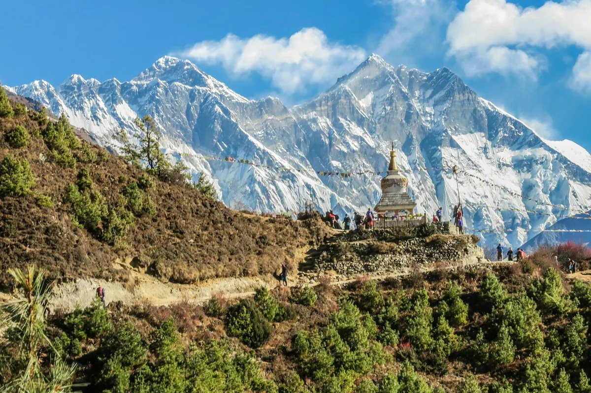 A white chorten on a ridge in the Everest region, with snow peaks behind