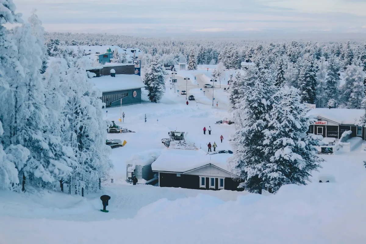 Snow-covered cabins in a Lapland forest